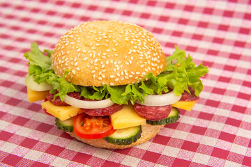 Hamburger with vegetables and sausage. Fast food and breakfast. Calories and diet.