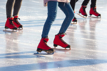 different people are actively skating on an ice rink. hobbies and leisure. winter sports