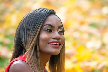 Beautiful young African girl autumn leaves background