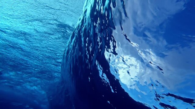Ocean wave. Underwater view of the clear ocean wave breaking over the hard reef bottom in Maldives