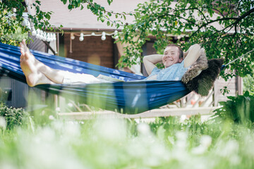 A man is resting and reading in a hammock. Day off and relaxation