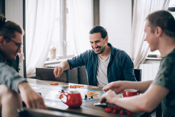 Friends play a board game in the living room