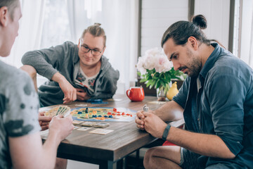 Friends play a board game in the living room