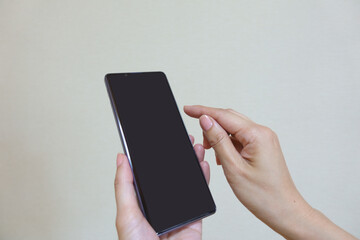 スマートフォンを操作する女性の手元のアップ　白バック