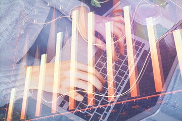 Double exposure of woman hands typing on computer and forex chart hologram drawing. Stock market invest concept.