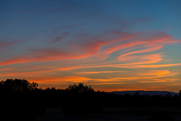 Obraz na płótnie Canvas Beautiful sunset with orange clouds in a blue hour sky