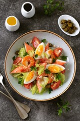 Salad with crab meat, shrimp, parmesan, capers, cherry tomatoes and lettuce. Healthly food.