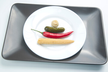 salad of canned and pickled mushrooms, cucumber and red pepper on a white plate.  food and vegetables. diet and weight loss