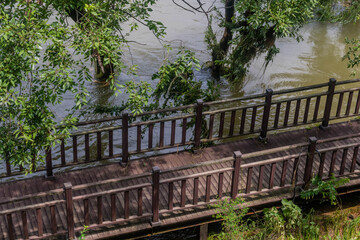 Fototapeta premium Surging water in flooded river just below boardwalk