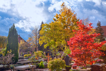Autumn in cemetery . Graveyard with colorful trees in the fall season . Johannisfriedhof Cemetery in Nuremberg