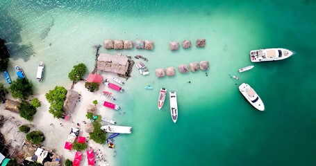 An aerian view of yachts on the beach of a tropical island