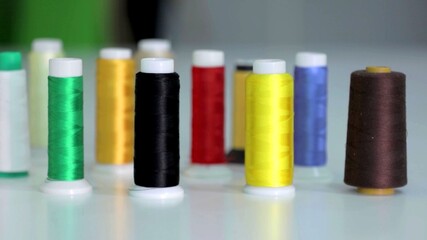 A photo of multicolored spools of sewing thread on a white background