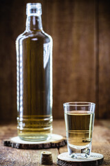 Glass of high quality distilled alcohol, called Cachaça (or drip) in Brazil, image of rustic wood, wine cellar or rustic bar.