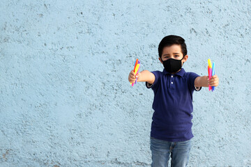 6-year-old boy with protective mask, lunch box and colors for back to school, new normal covid-19