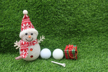 Naklejka premium Golfer Christmas Holiday with Snowman with golf ball on green grass
