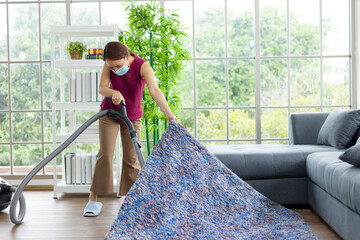 Asian housewife vacuuming on the floor.