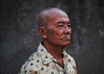 asian senior man with bald head, view from the side