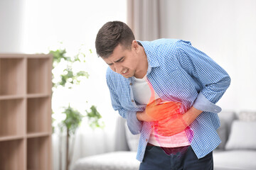 Young man suffering from stomach ache at home