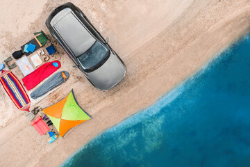 Car and camping equipment on sandy beach, aerial view. Summer trip