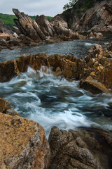 Rocky seashore, rough stones on the seashore, coast Primorye territory telyakovsky Bay of the Pacific Ocean, summer seascape.