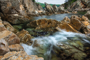 Rocky seashore, rough stones on the seashore, coast Primorye territory telyakovsky Bay of the Pacific Ocean, summer seascape.