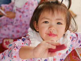 Little baby girl, 2 years old, enjoys putting on / using her mom's lipstick - child playing make up