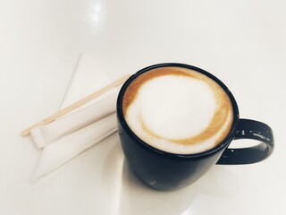 Black coffee mug, holds a cappuccino with fizzy milk.