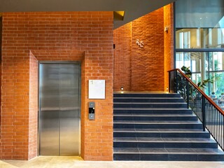 Elevator and fire escape, decorated with red brick walls.