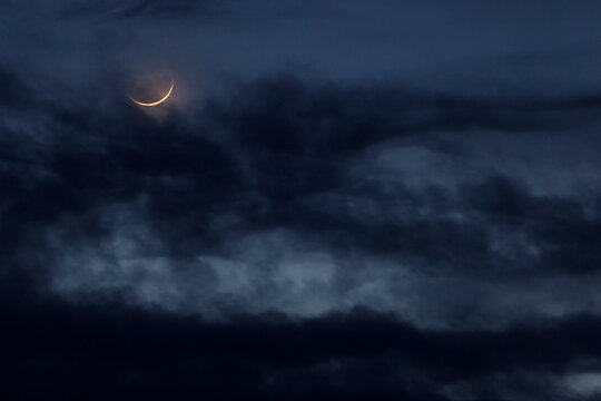 Crescent moon with black clouds