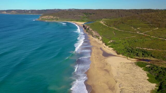 Tracking drone shot of cliffs and ocean at Merewether, New South Wales