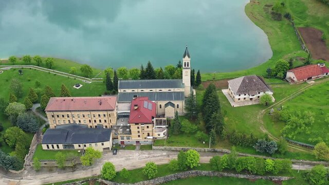 Drone shot flying left to right over a beautiful castle. Peaceful lake Rama, Bosnia.