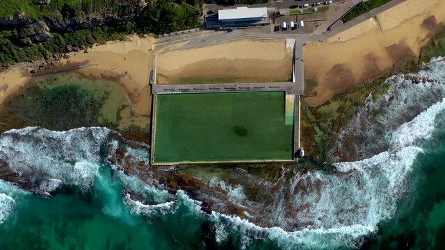 Rising drone shot of ocean bathes at Merewether, New South Wales