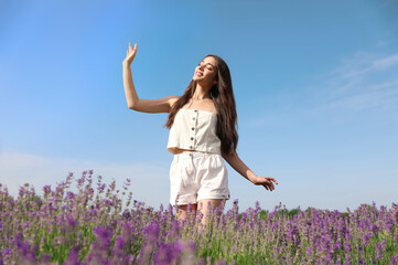 Naklejka na ściany i meble Young woman in lavender field on summer day