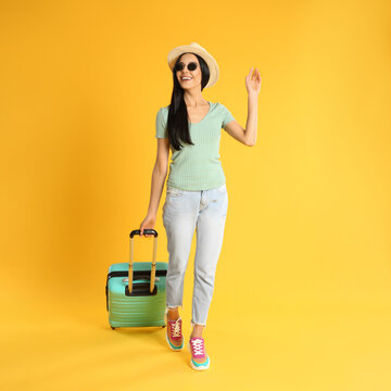 Beautiful Woman With Suitcase For Summer Trip On Yellow Background. Vacation Travel