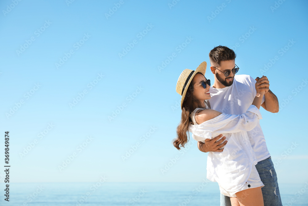 Wall mural happy young couple dancing at beach near sea. honeymoon trip