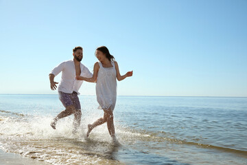 Happy young couple having fun at beach. Honeymoon trip