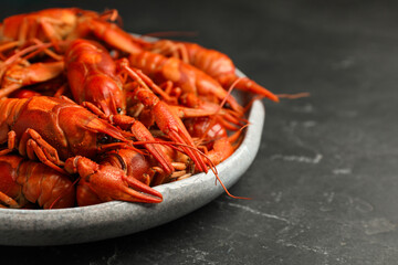 Delicious boiled crayfishes on black table, closeup