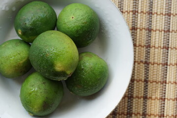 Close up flat lay of dewy limes on a plate