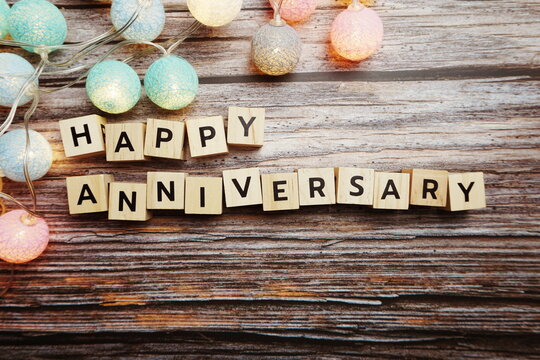 Happy Anniversary Alphabet Letter With LED Cotton Ball Decoration On Wooden Background