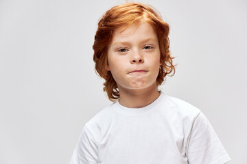 Cute redhead boy in white t-shirt lifestyle close-up cropped view 