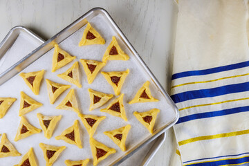Triangle cookies on oven tray with tallit.