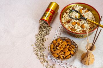 Khohloma bowl and spoon with oatmeal, raisins, nuts and seeds. Healthy  breakfast concept on beige linen background. Flatlay.