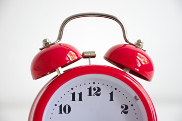 Red vintage alarm clock against the white background