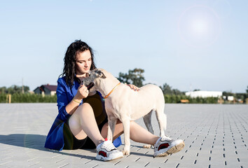young attractive woman playing with her dog in the park