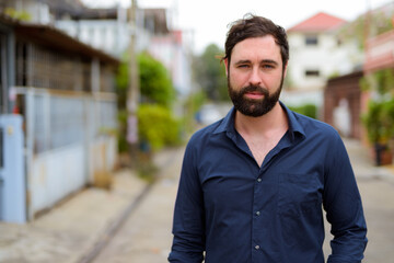 Portrait of handsome businessman with beard outdoors