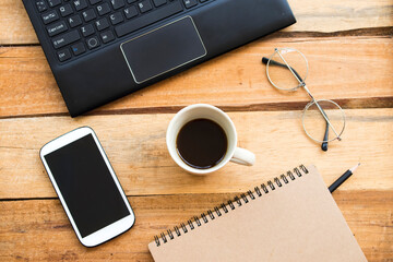 notebook planer ,mobile phone ,computer for business work with hot coffee arrangement flat lay style at office on background wooden
