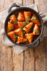 Delicious hot cabbage rolls with meat and rice in tomato sauce close-up in a bowl on the table. Vertical top view from above