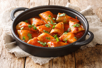 Traditional stuffed cabbage with minced meat and rice, served in a tomato sauce close-up in a bowl. Horizontal