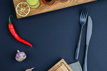 Elegant table setting: black cutlery with linen on black table. Flat lay, copy space banner. Restaurant concept.