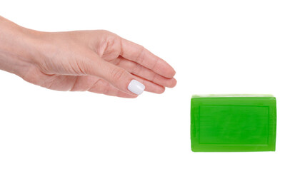 Hand with handmade green soap bar, isolated on white background.